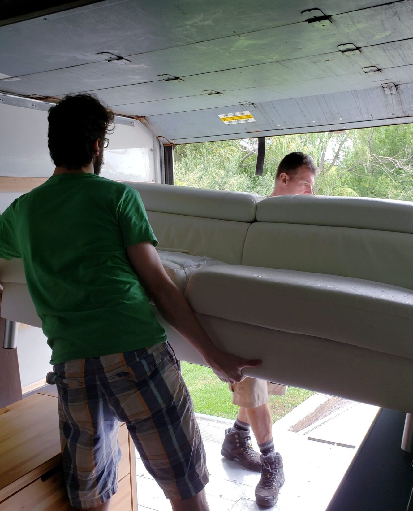 father-and-son-carrying-sofa-from-movers-truck-on-2023-11-27-05-18-58-utc